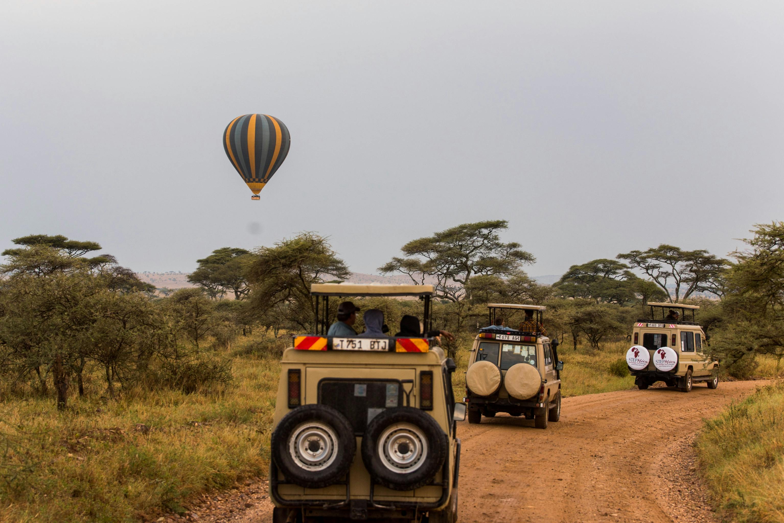Flying Hot Air Balloon and Off-road Vehicles with Tourists on Safari in Tanzania